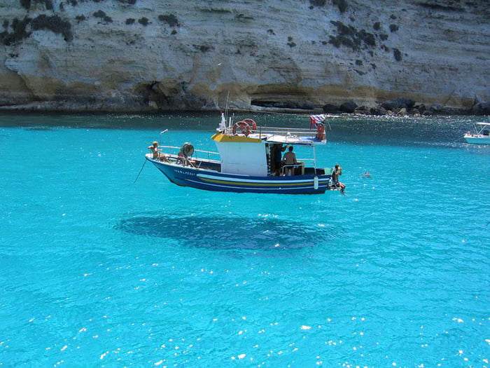 The water is so clear that it made the boat looks like its f